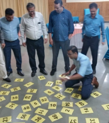 People gathered around a table, where numbers were displayed, and engaged in a sales discussion.